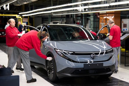 Four workers inspect a completed Leaf electric car
