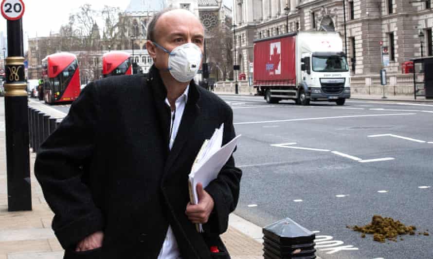 Dominic Cummings portant un masque facial et marchant près de la place du Parlement