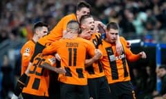 Danylo Sikan is mobbed by Shakhtar Donetsk players after his header against Barcelona