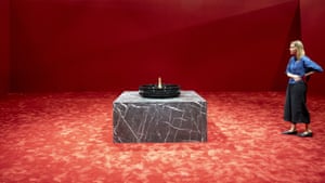 Red carpet and woman looking at object on plinth