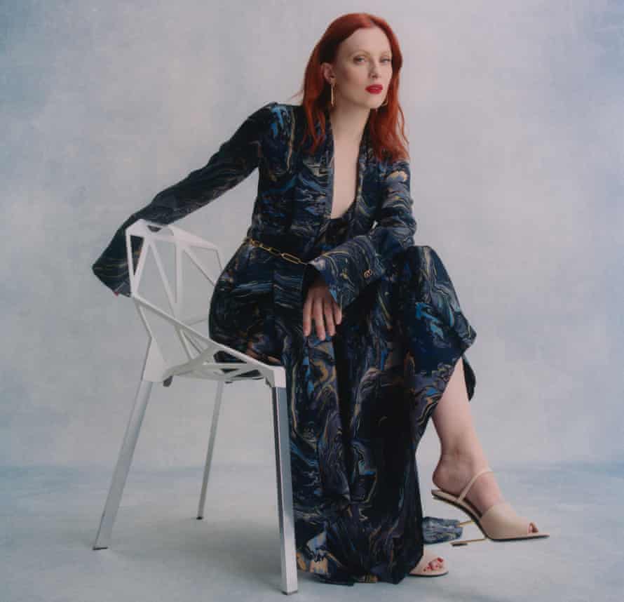 Model Karen Elson sitting on a white chair against a grey background