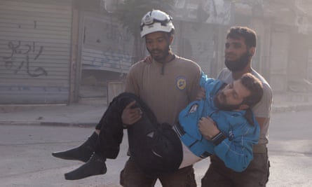 Rescuers help a wounded man in the Saladin neighbourhood of eastern Aleppo.