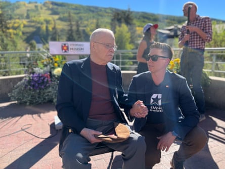 two people talking on a bench in the sunlight