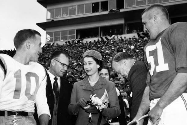 Queen Elizabeth looks slightly bemused as she attends an American football match and meets the players in 1957.
