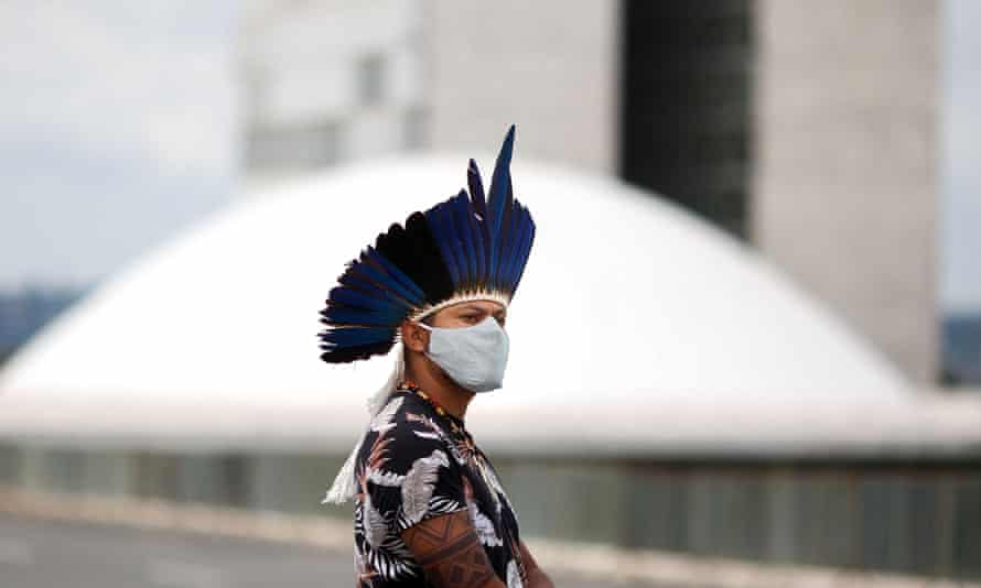 An indigenous man wears a protective mask during a protest against the president Jair Bolsonaro’s mining politics regarding indigenous lands, and demanding the Brazilian environment minister Ricardo Salles’ resignation, outside the Ministry of the Environment building in Brasilia.