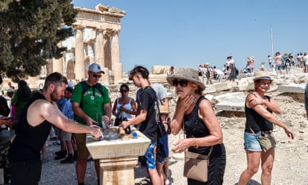 Un gruppo di persone presso una fontana vicino all'Acropoli