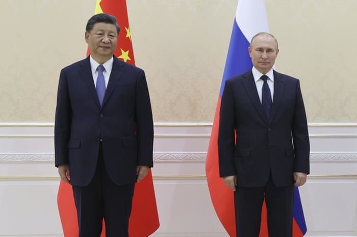 Xi, left, and Putin stand in front of the flags of their respective countries