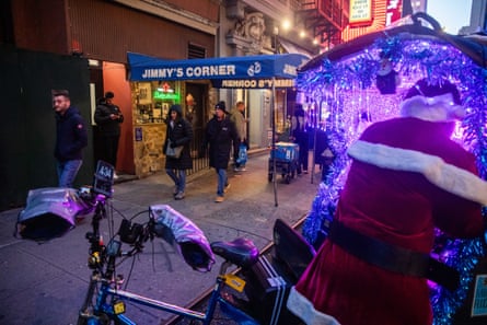 people walk past a bar on a sidewalk