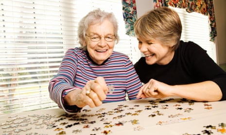 Elderly woman and younger woman doing a puzzle.