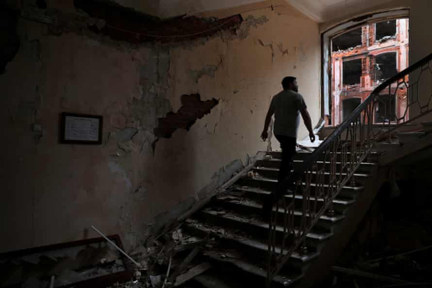 Russia-Ukraine war latest: Putin warns of new targets; Zelenskiy visits troops on eastern front – live | Ukraine 6 A man walks up the stairs inside a building of Kharkiv National University which has been destroyed by Russian attacks.