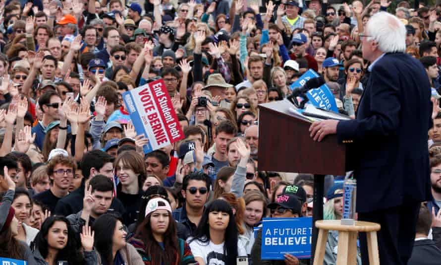 Students put up their hands when Bernie Sanders asks them how many have student debt.