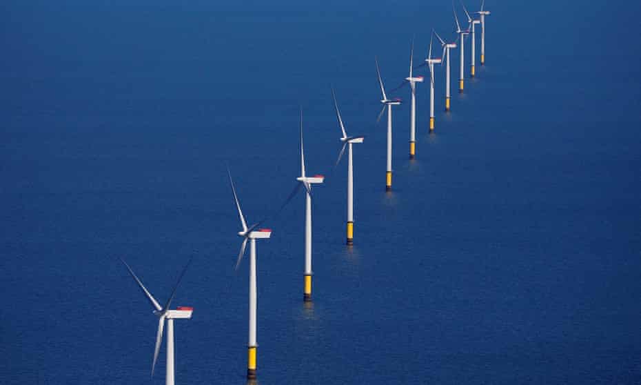 Row of wind turbines in sea.