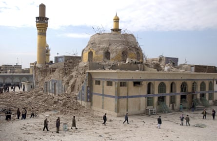 Iraqis walk past the damaged al-Askari shrine after an explosion in Samarra, north of Baghdad, Iraq in February 2006.