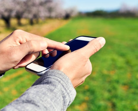 man using a smartphone in a natural landscape