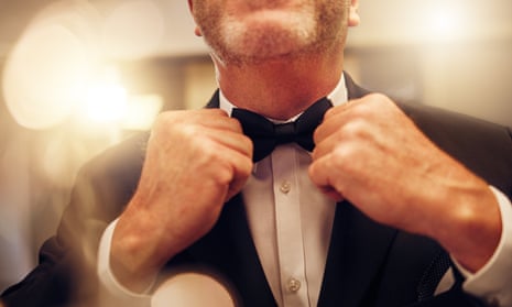Man in a dinner jacket, adjusting his bow tie