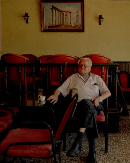A customer sits with small cup of coffee at a cafe