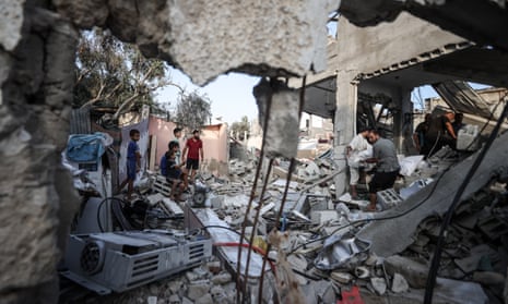 Palestinians examine the heavily damaged buildings and collect remaining belongings from the rubble of heavily damaged houses after the Israeli attacks on Maghazi Refugee Camp and other refugee camps such as Nuseirat Refugee Camp in Deir al-Balah of Gaza on July 16, 2024.