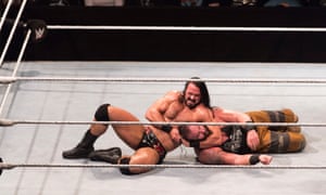 Drew McIntyre holding Braun Strowman in a headlock on the floor of a wrestling ring, Germany, 2018.