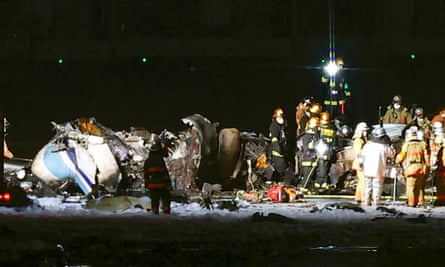 Firefighters at the wreckage of the Japan Airlines plane.