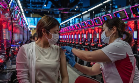 A woman receives a dose of a Covid vaccine in a pachinko parlour in Osaka, Japan.