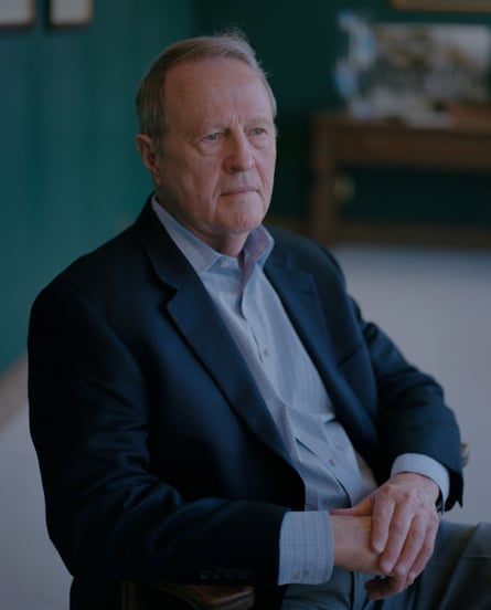 a man wearing a suit sits for a portrait indoors
