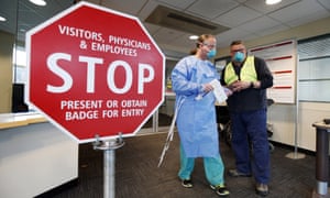 Medical personnel discuss patients that had been admitted for testing for the coronavirus at the entrance Central Maine Medical Center on Friday.