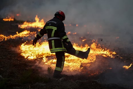 Ένας πυροσβέστης εργάζεται καθώς οι φλόγες καίγονται κατά τη διάρκεια μιας πυρκαγιάς