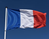 The blue, white and red French flag flying against a deep blue sky.
