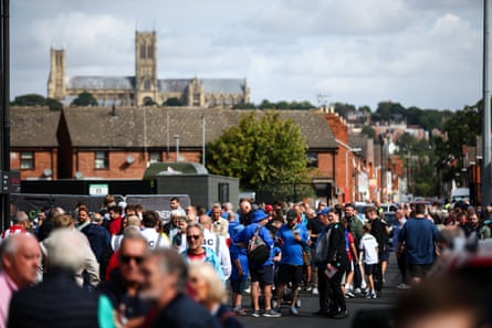 A small group of Portsmouth fans in among many more Lincoln fans celebrate their team’s 3-1 Championship win. Lincoln Cathedral is visible in the background.