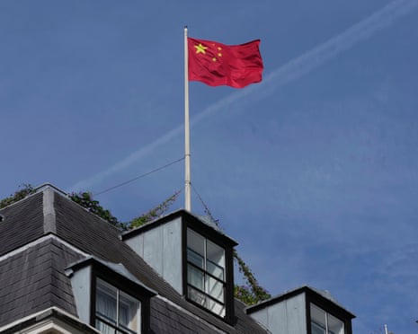 Chinese flag flies atop building with blue sky behind