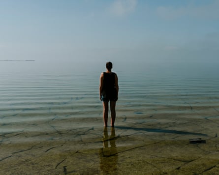 Rear view of woman looking at sea while standing against sky