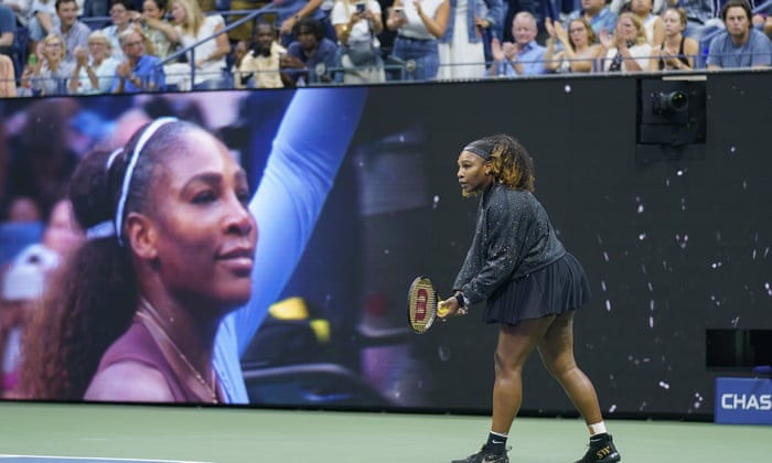 Serena Williams warms up in front of a large display welcoming her to the court.