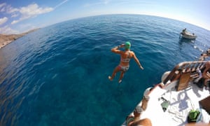 Female swimmer jumps from a boat in the swim, as part of the Minoan Trail swimming trip, in Crete