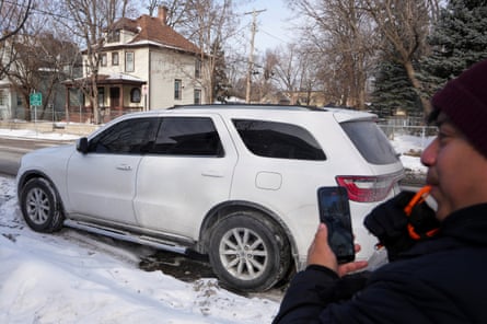 A man uses a whistle to alert neighbors about a vehicle believed to being used by federal agents in south Minneapolis on 26 January 2026.
