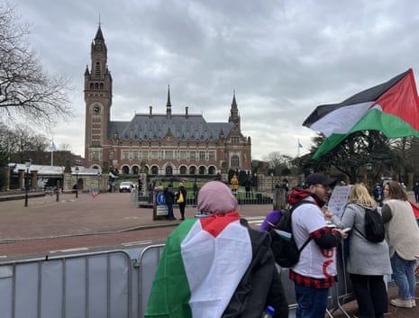 People demonstrate with Palestinian flags outside the International Court of Justice in The Hague, the Netherlands.