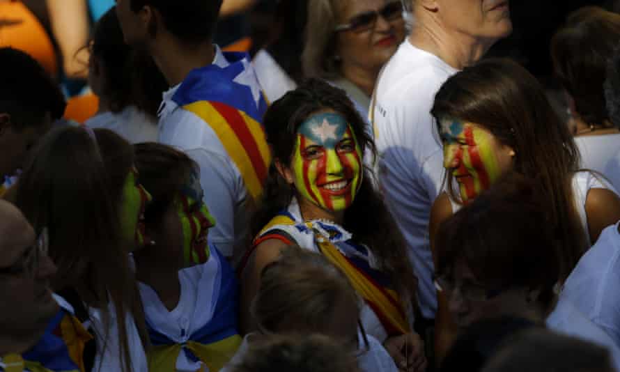 Pro-independence marchers with their faces painted with the Catalan <em>Estelada</em> flag.