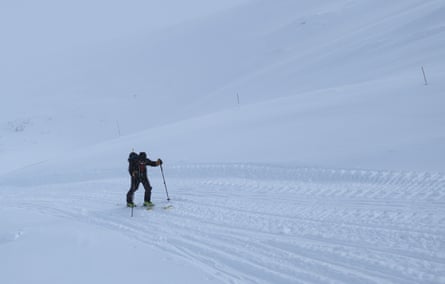 A man skiing up a steep snowy hill