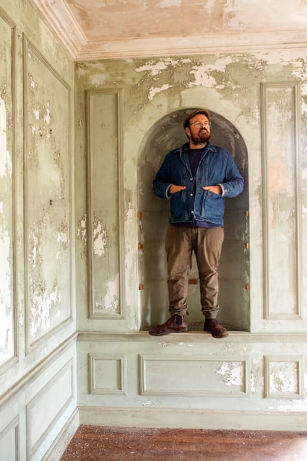 Banjo Beale standing inside a Georgian-looking alcove with peeling green paint