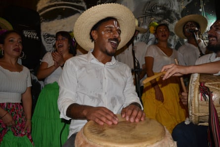 A man hits a drum at a party.