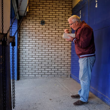 A fan eats chips outside an exit on Goodison Road
