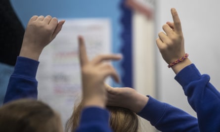 Children raising their hands in a classroom