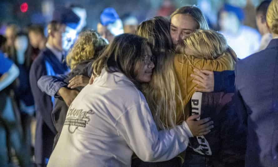 People hug each other during a vigil for the shooting victims in Santa Clarita.
