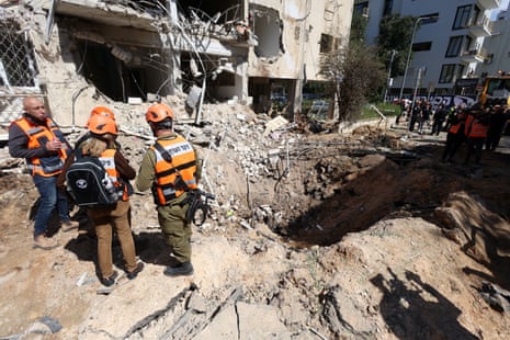 Emergency personnel work at the site following Iranian missile barrages in Tel Aviv, on 24 March 2026.