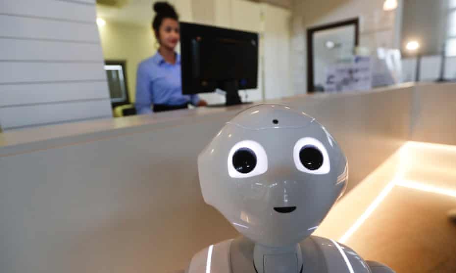 A robot works alongside a woman at the front desk of a hotel in Peschiera del Garda, Italy.