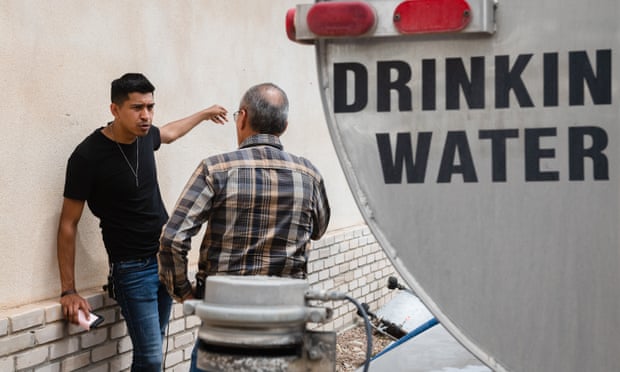 Jack Duran talks with the driver of a water truck. Residents without tapped water sometimes pay as much as of $250 a month.