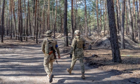 Ukrainian servicemen in the forest near Izium, where 450 graves were discovered after the city was recaptured from the Russians. 