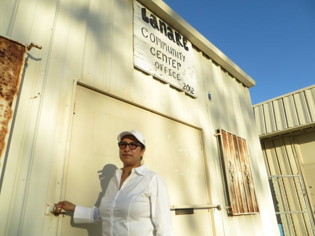 Isabel Solorio stands next to the defunct water treatment plant across from her home in Lanare.