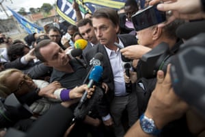 National Social Liberal Party presidential candidate Jair Bolsonaro talks to the press at the Madureira market in Rio de Janeiro, 27 August.