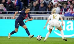 PSG's Sakina Karchaoui, left, runs with the ball at Lyon's Ellie Carpenter during the first leg of their semi-final