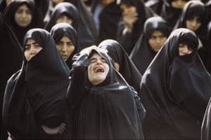 Women wearing black burkas cry at the procession for the Ayatollah Khomeini, who died at the age of 89